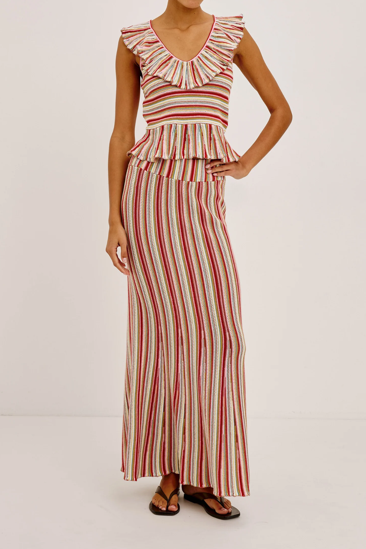 Woman wearing a red and white striped skirt on a plain background