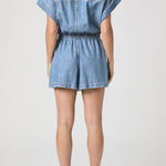 Denim romper worn by a person on a white background