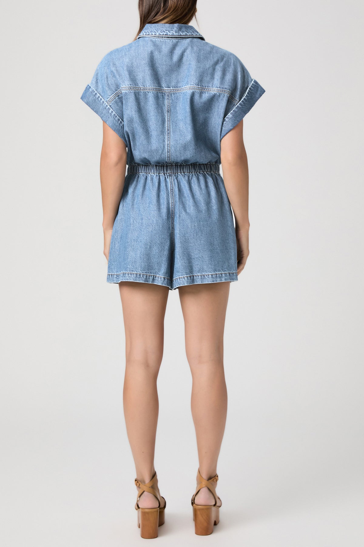Denim romper worn by a person on a white background