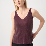 Woman wearing a maroon tank top against a white background
