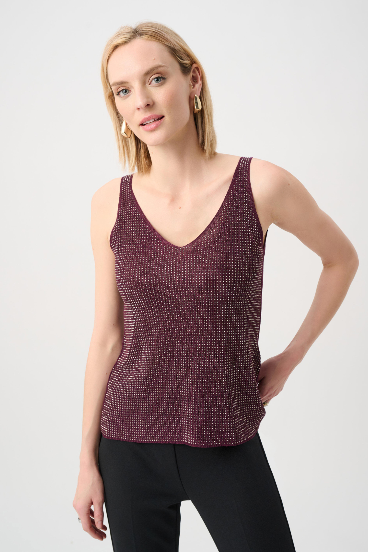 Woman wearing a maroon tank top against a white background