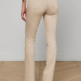 Person wearing beige flared pants and a matching top against a plain background