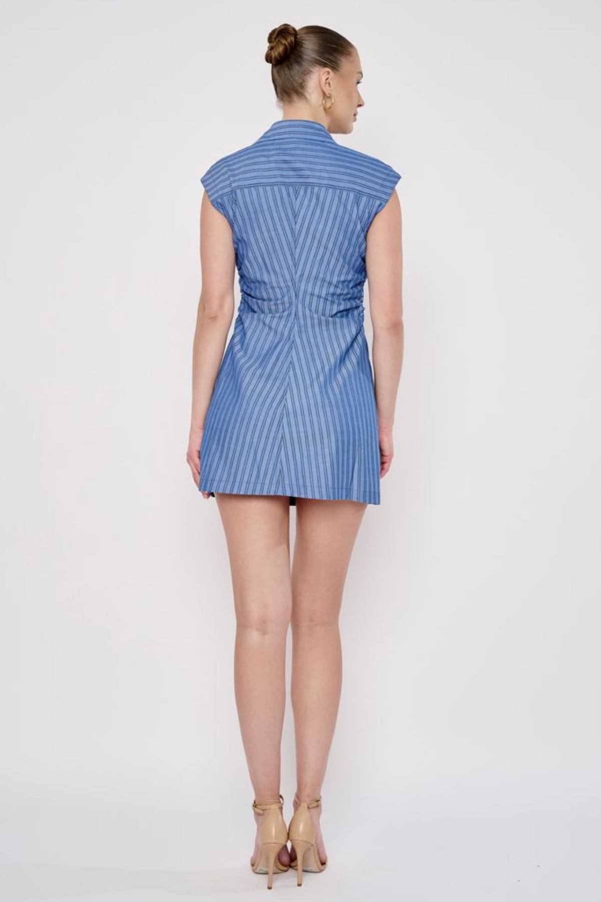 Model wearing a sleeveless striped mini dress with a relaxed fit and classic blue-and-white stripe pattern.