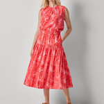 Woman wearing a red patterned dress on a gray background