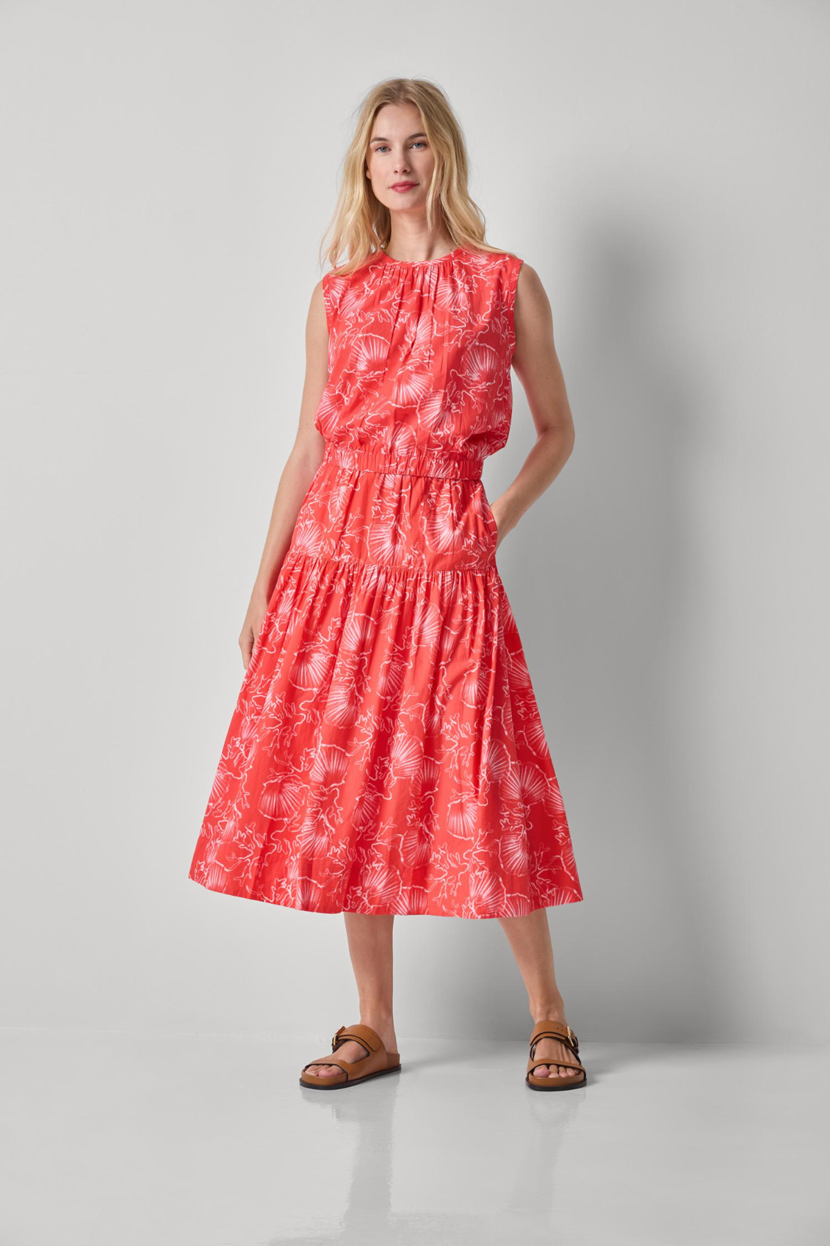 Woman wearing a red patterned dress on a gray background