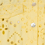 close up of yellow lace cutout jacket on white background 