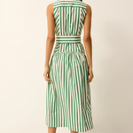 Woman wearing a green and white striped dress against a plain background