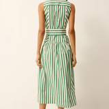 Woman wearing a green and white striped dress against a plain background