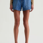 Person wearing blue denim shorts on a plain background