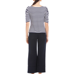 Woman wearing a striped shirt and wide-leg pants on a white background