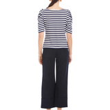 Woman wearing a striped shirt and wide-leg pants on a white background