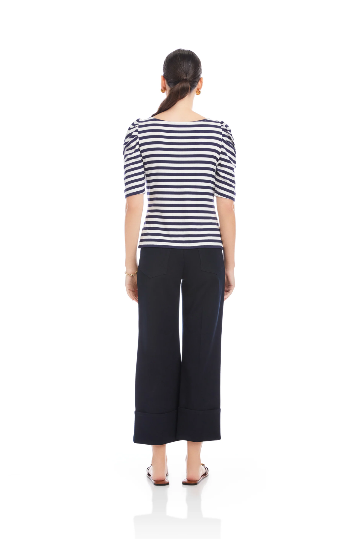 Woman wearing a striped shirt and wide-leg pants on a white background