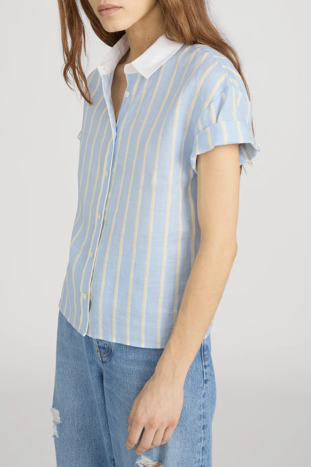 side view of woman in stripe button down short sleeve on white background 