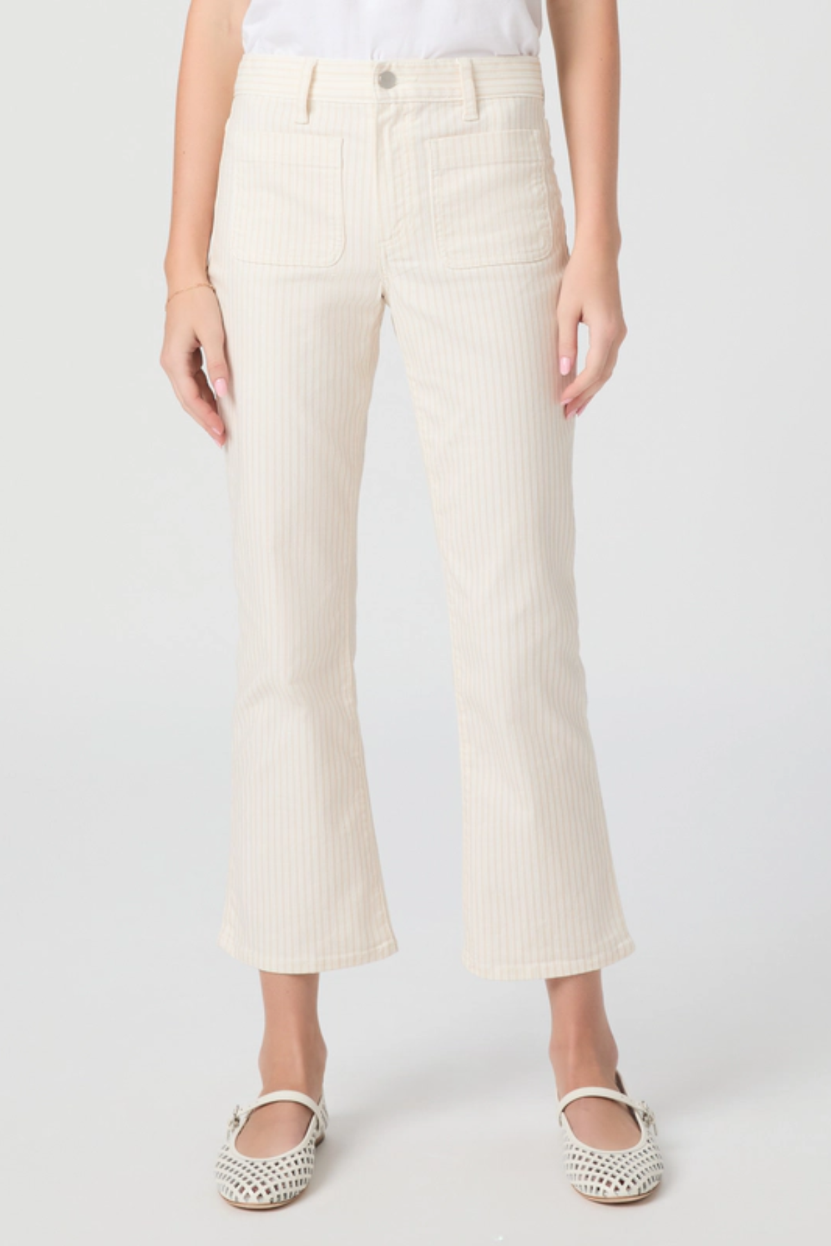 Person wearing white ribbed pants on a plain background