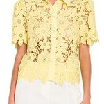 Yellow lace blouse worn by a person on a plain background