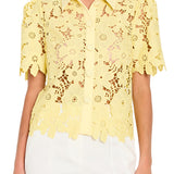 Yellow lace blouse worn by a person on a plain background