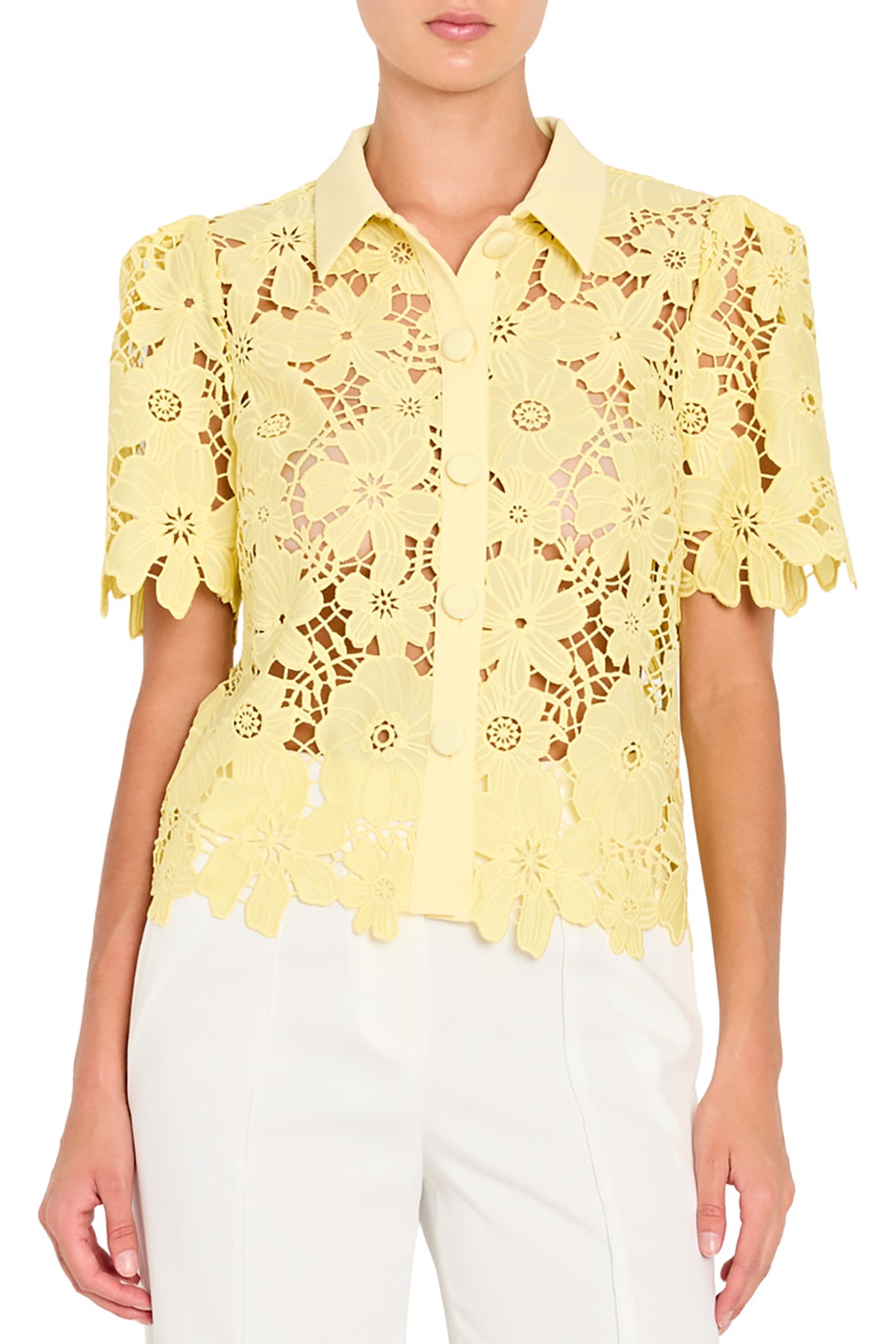 Yellow lace blouse worn by a person on a plain background