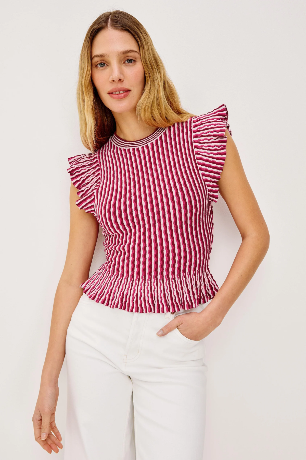 Woman wearing a red and white striped top with ruffled sleeves against a white background