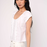 Woman wearing a white blouse against a plain background