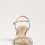 Gold sandal with 'Sam Edelman' branding on a white background