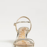 Gold sandal with 'Sam Edelman' branding on a white background