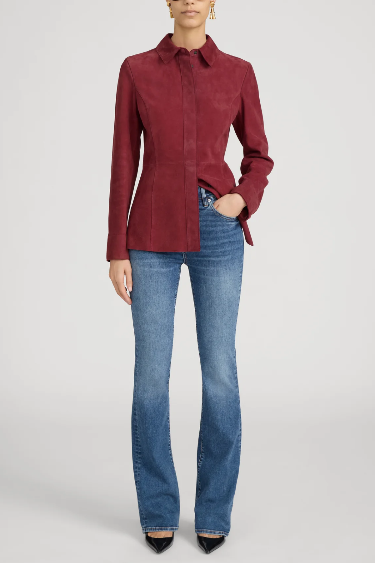 Person wearing a red shirt and blue jeans on a white background