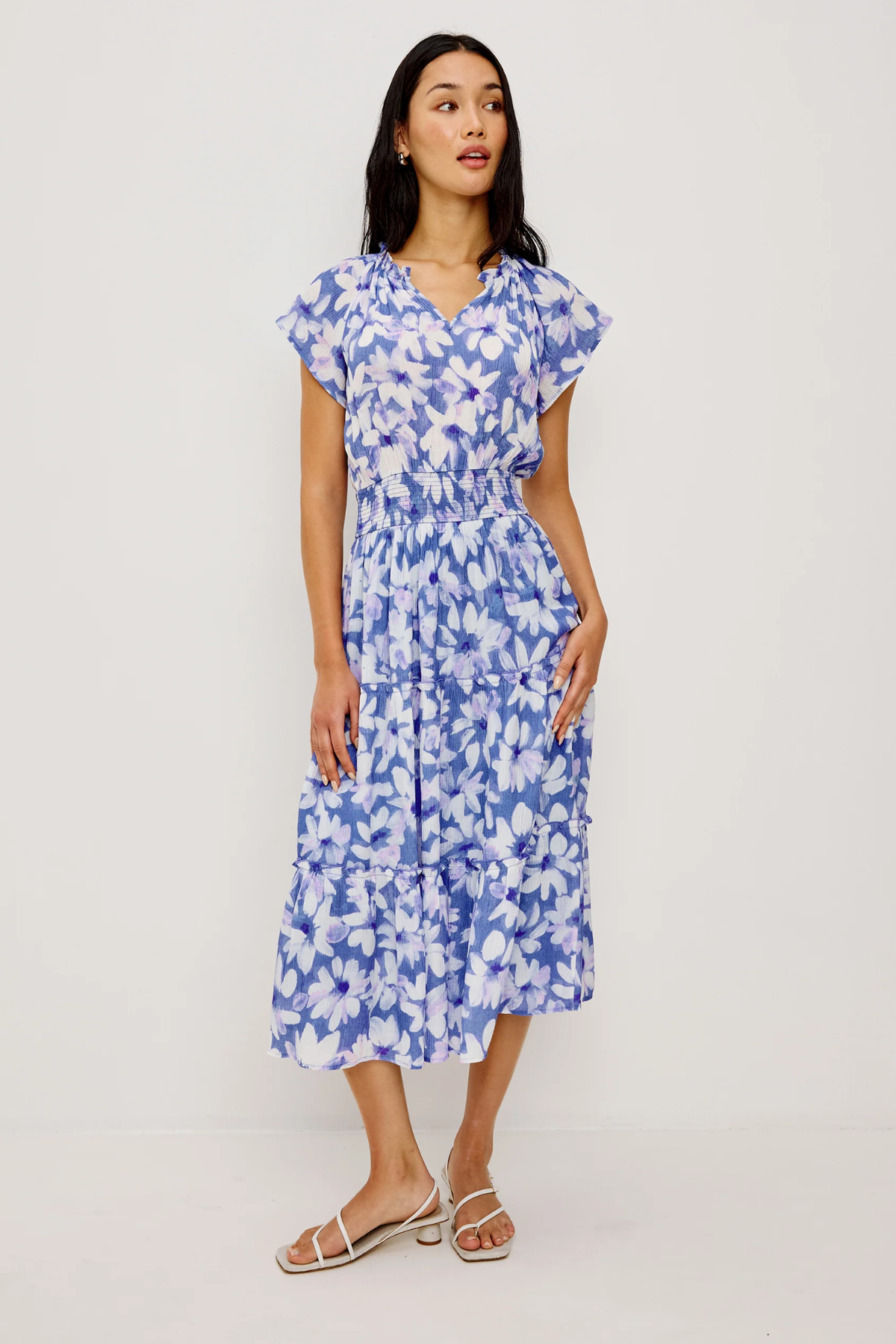 Woman wearing a blue floral dress on a white background