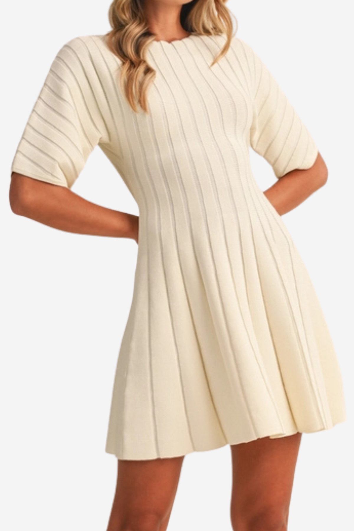 A woman wearing a cream-colored short-sleeve ribbed knit dress with a flared skirt, shown against a plain light background.
