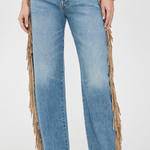 Light blue wide-leg denim jeans with long tan fringe draped down the outer sides, shown on a model against a plain light background.