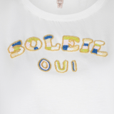 close up of beaded t-shirt on white background 