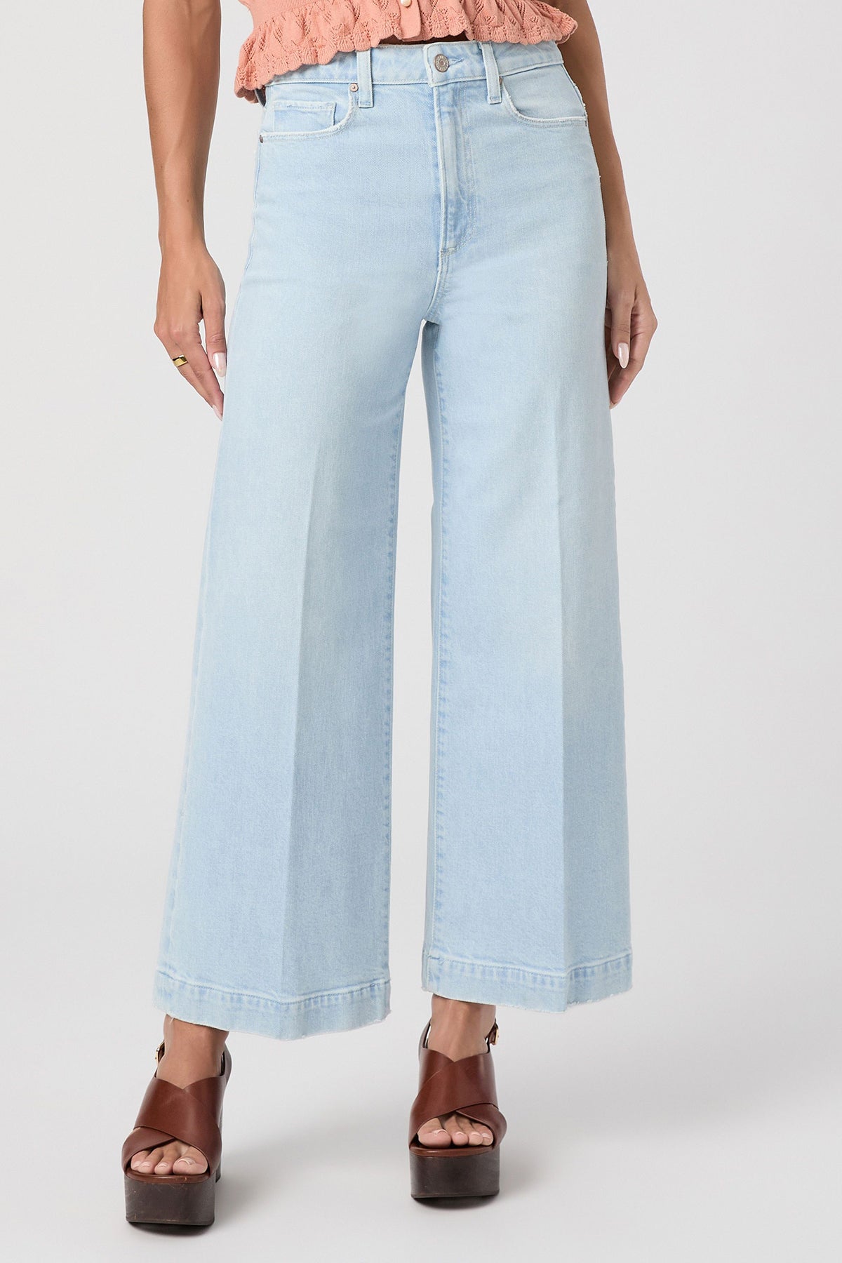 Light blue jeans worn by a person on a white background