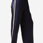 A person wearing loose navy wide-leg pants with two vertical white side stripes, paired with black flats, shown against a plain light background.