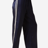 A person wearing loose navy wide-leg pants with two vertical white side stripes, paired with black flats, shown against a plain light background.