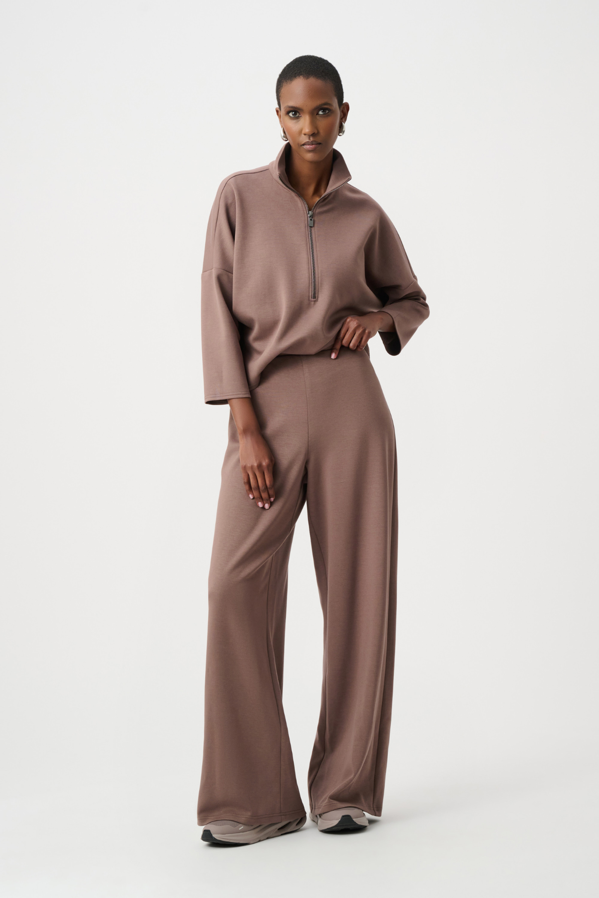 Woman wearing a brown outfit on a white background