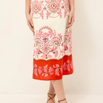 Red and white patterned skirt worn by a person on a plain background