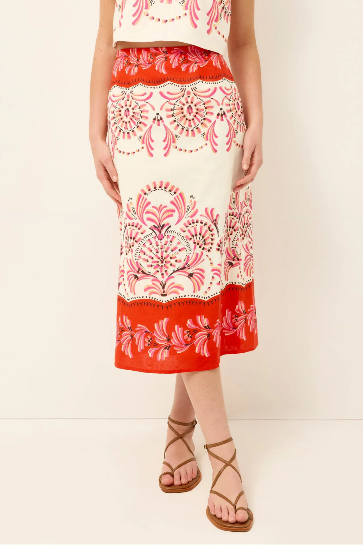 Red and white patterned skirt worn by a person on a plain background