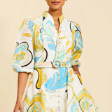 Woman wearing a colorful patterned dress against a beige background