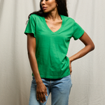 woman in green shirt on tan background 