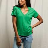 woman in green shirt on tan background 