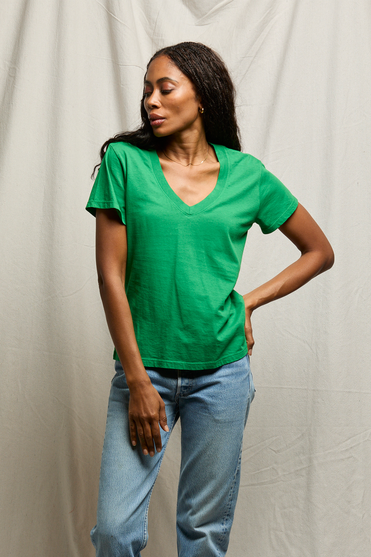 woman in green shirt on tan background 