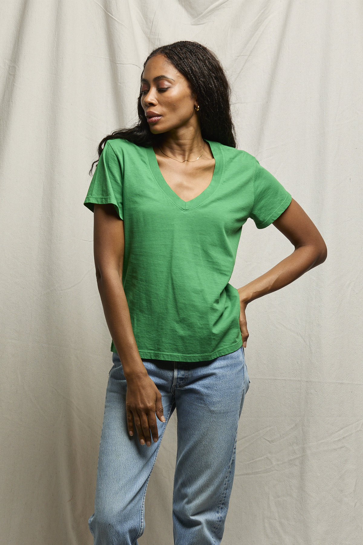 woman in green shirt on tan background 