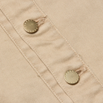 Close-up of beige fabric with buttons on a garment