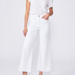 Woman wearing a white outfit with black sandals on a white background