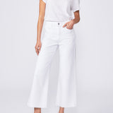 Woman wearing a white outfit with black sandals on a white background