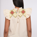Model wearing an ivory sleeveless blouse with a relaxed fit.