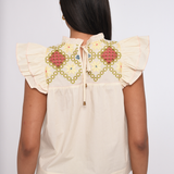 Model wearing an ivory sleeveless blouse with a relaxed fit.