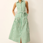 Woman wearing a green and white striped dress against a plain background