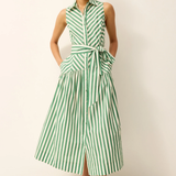 Woman wearing a green and white striped dress against a plain background