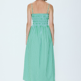 Woman wearing a green striped dress on a white background