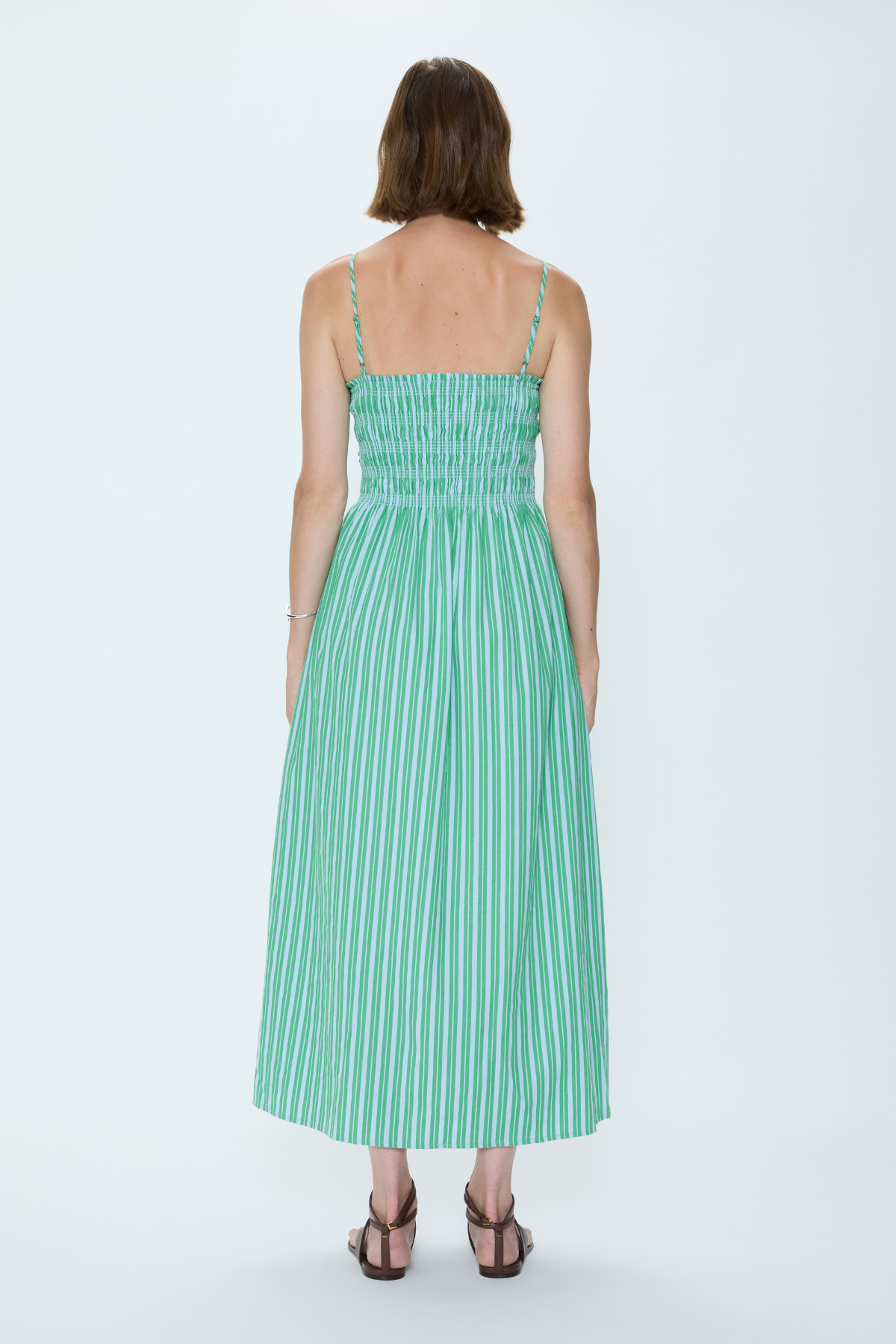 Woman wearing a green striped dress on a white background